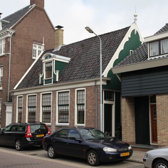 Huis met recht opzij een houten topgevel en in de onderpui een deurkalf met anno 1700