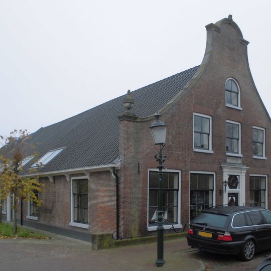 Langgerekte, met oud-hollandse pannen gedekte boerderij met voorname gevel