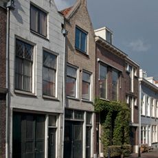 Pand met geverfde puntgevel met geprofileerde zijafdekstukken en oude raamkozijnen