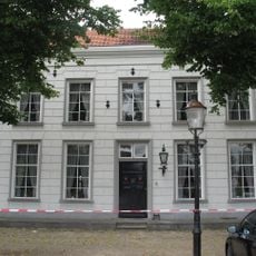 Herenhuis met gebosseerd gepleisterde lijstgevel onder schilddak