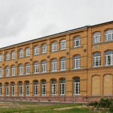 Drei Produktionsgebäude, Turbinenhaus und Schaltanlagenhaus einer Fabrikanlage sowie Schausammlung historischer Laborgeräte und Siebwalzen, weiterhin Kollergang