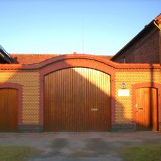 Hofmauer eines Bauernhofes mit großem Torbogen und zwei kleinen Pforten Dorfstraße 50