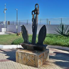 Una antigua ancla de grandes dimensiones a modo de escultura pública.