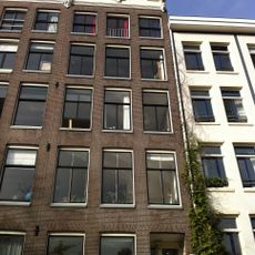 Pand met gevel onder verhoogde gesneden lijst met kuif