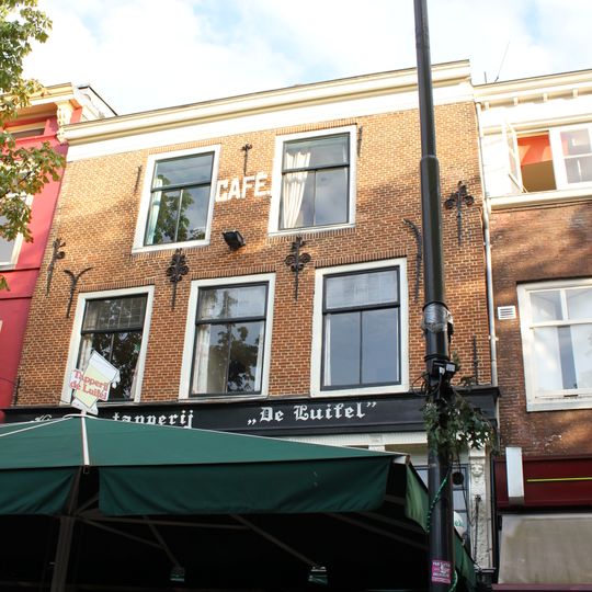 Pand met twee bouwlagen onder rood pannen schilddak dat boven de tot lijstgevel verbouwde oorspronkelijk trapgevel is afgewolfd