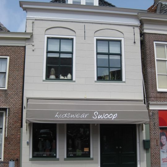 Pand met gepleisterde gevel onder zadeldak