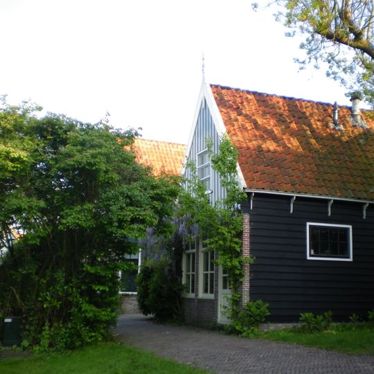 Houten woonhuis onder met pannen gedekt zadeldak