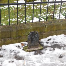 Fragment litinového kříže před farou ve Střešovicích