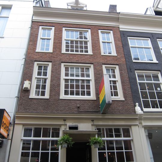 Huis waarvan de gevel, die zijn bekroning heeft verloren, een provisorische afsluiting heeft