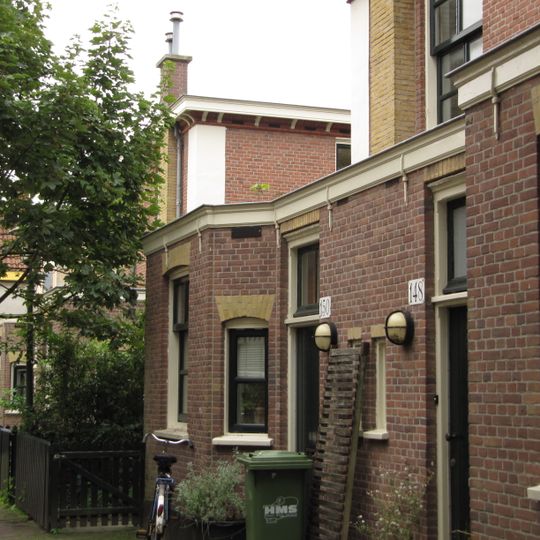 Blok van vier rug-aan-rug gebouwde woningen op vierkante plattegrond, bestaande uit begane grond en verdieping onder een plat dak