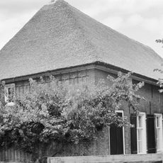 Boerderij op T-vormige plattegrond. Vensters met luiken en zesruitsschuiframen