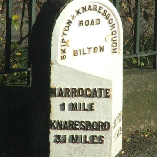 Milestone, metal plate attached to stone post, Skipton Road, Bilton, in front of Bilton Grange school