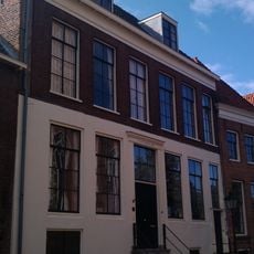 Hoog pand met aan drie zijden omlopend schilddak