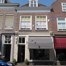 Huis met schilddak en zeer eenvoudige lijstgevel; latere winkelpui