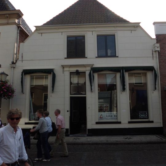 Huis met gepleisterd lijstgeveltje met afgeschuinde bovenhoeken