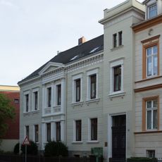 Wohnhaus, nach rechts in geschlossener Bebauung mit südöstlich vom Haus gelegenen Remisen und Garten Mühlweg 22
