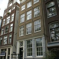 Huis met gevel onder rechte lijst met triglyfen en consoles