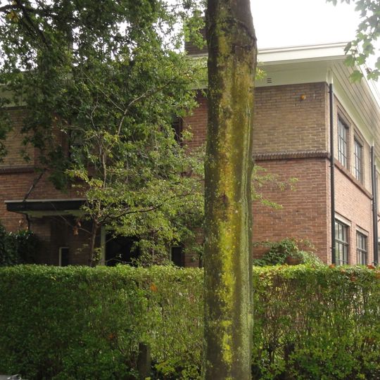 Vier woningen met poort en schuurtjes