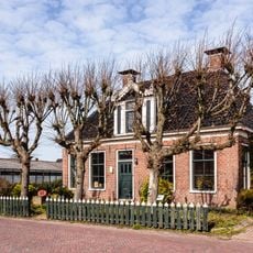 Woonhuis met ingang in het midden onder schilddak met hoekschoorstenen