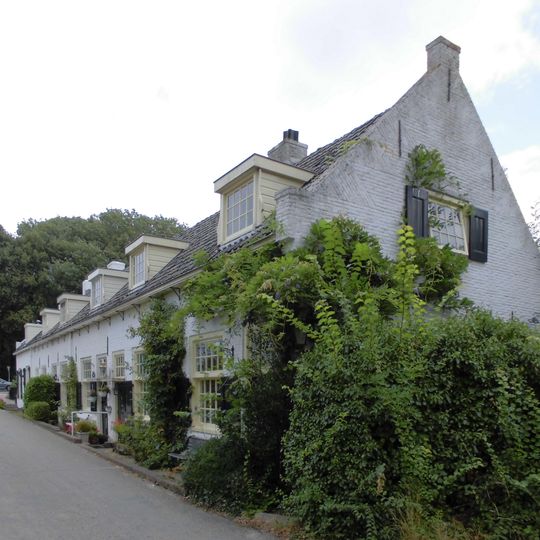 Gepleisterde lage huizen, ramen met kleine roeden en halve luiken, topgevel en zadeldak
