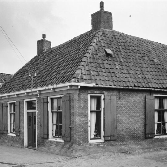 Woning met zesruitsvensters onder schilddak met hoekschoorstenen