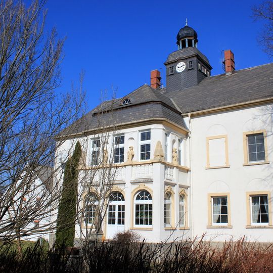 Herrenhaus einschließlich seitlich angebauter Mauer und zwei gemauerte Pfosten mit geschweiften Aufsätzen als Einfriedung ; Hauptstraße 11
