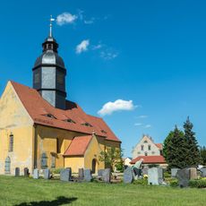 Kirche (mit Ausstattung), Kirchhof mit Einfriedung, Kriegerdenkmal für die Gefallenen des 1. Weltkrieges sowie Epitaph in der Kirchenwand und drei Grabmale an der Kirchhofsmauer Baudaer Straße 4a