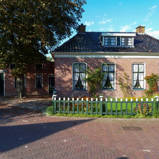 Landelijk pand onder laag schilddak met hoekschoorstenen