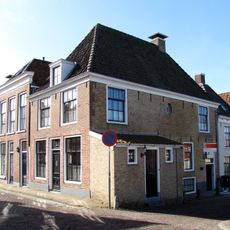 Eenvoudig woonhuis met gepleisterde gevel onder schilddak