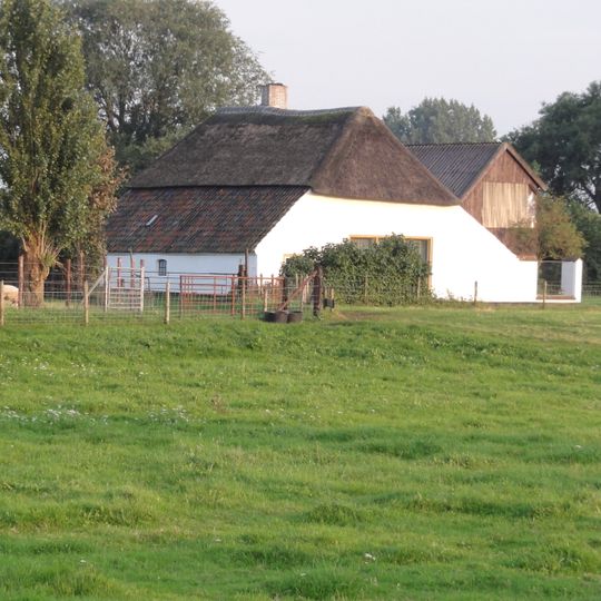 Gepleisterde boerderij onder met riet en pannen gedekt wolfdak
