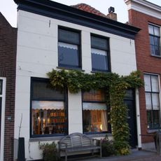 Huis met gepleisterde lijstgevel met stoep