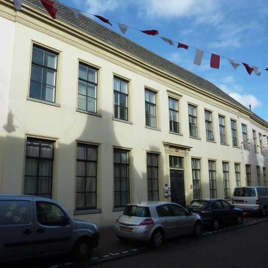 Pand met brede lange lijstgevel, gepleisterd, enigszins uitgebogen