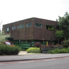 Houten woning van twee bouwlagen onder een plat dak.