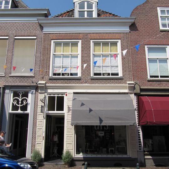 Huis met schilddak en zeer eenvoudige lijstgevel; latere winkelpui