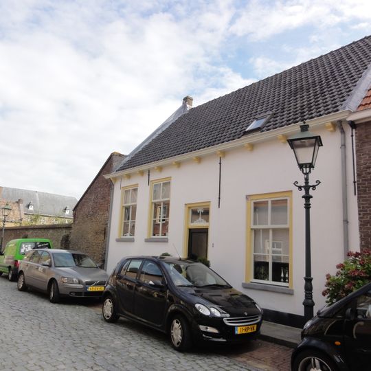 Huis met zadeldak tussen zij-topgevels en met gepleisterde lijstgevel,