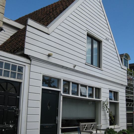 Houten dijkhuis met tuitgevel uit 20ste eeuw, aan achterzijde tuitgevel