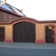 Hofmauer eines Bauernhofes mit großem Torbogen und zwei kleinen Pforten Dorfstraße 26