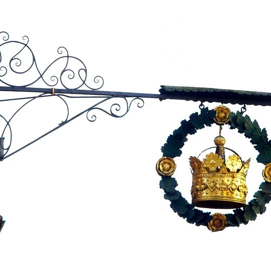 Wirtshausausleger mit goldener Krone im Kranz