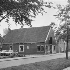 Pand onder zadeldak tussen topgevels; houten topgevelbeschieting aan de voorzijde.
