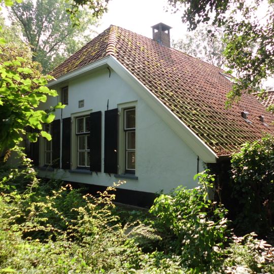 Boerderij, witgepleisterd bakstenen gebouw onder afgewolfde rieten zadeldak