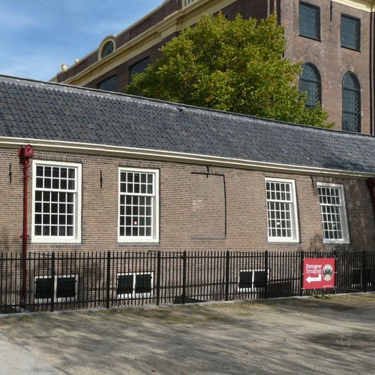 Lage dienstwoningen onder om de hoek van de Rapenburgerstraat omlopend schilddak