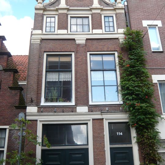 Pand met klokgevel, fraai met pilasters bekroond door Korinthische kapitelen en horizontale lijsten, vazen op de hoeken