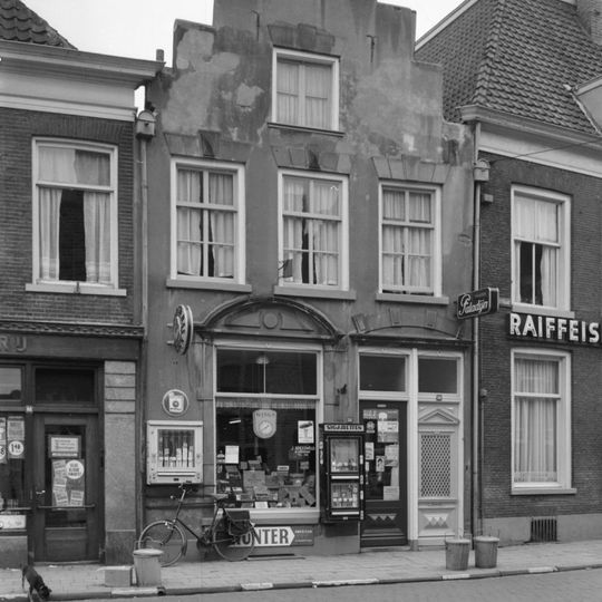 Pand met gecementeerde trapgevel met op de toppilaster een sieranker