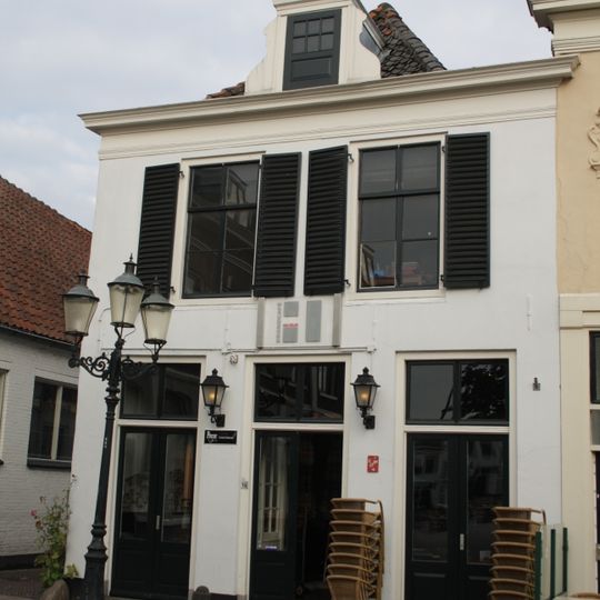 Huis met lijstgevel, gepleisterd, gewitte zijgevel. Achterhuis