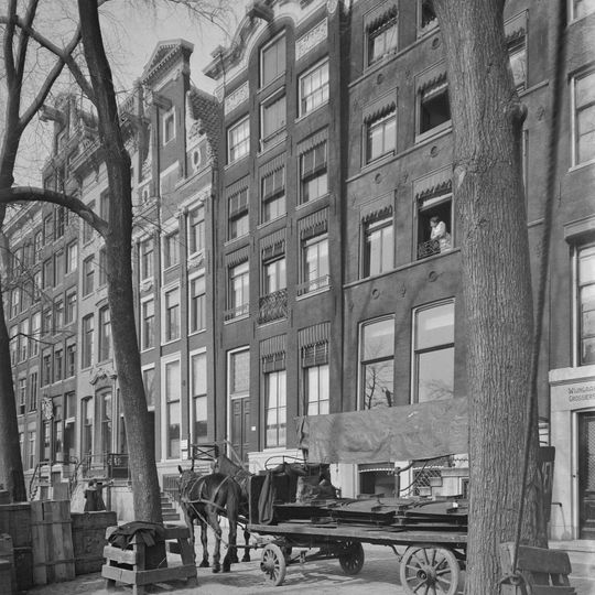 Pand met gevel onder stenen in het midden getoogde lijst met siervazen