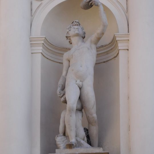 Mužská postava na levé straně fasády Vysoké školy uměleckoprůmyslové v Praze