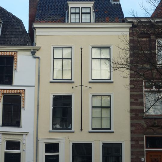 Pand met gepleisterde gevel met rechte kroonlijst. Zadeldak