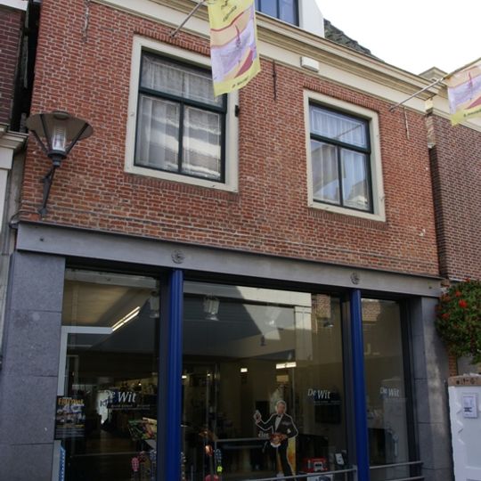 Pand onder diep zadeldak tegen oude achtergevel van puntvorm