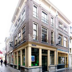 Pand met gepleisterde lijstgevel, de lijst voorzien van consoles