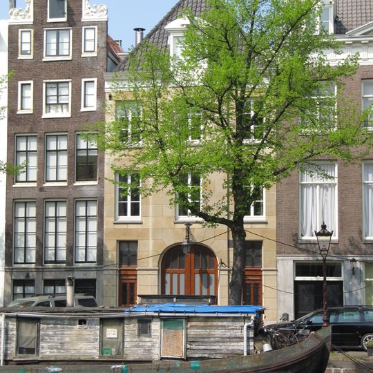 Koetshuis met zandstenen gevel voorzien van brede boogdeuren in de middenrisaliet